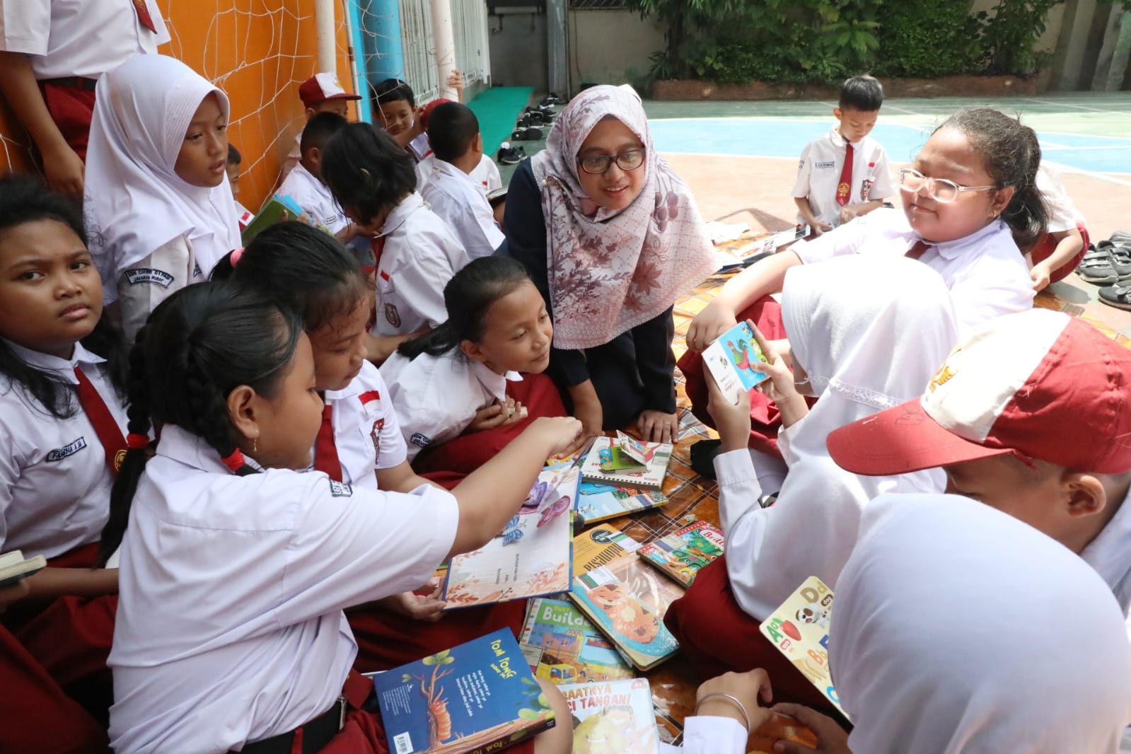 Anak Membaca Buku didampingi oleh guru